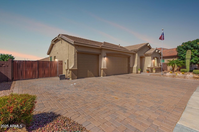 1036 W Siebold Tree Ave, Queen Creek, AZ 85140 - view of front facade featuring stucco siding, an attached garage, decorative driveway, a gate, and a tiled roof