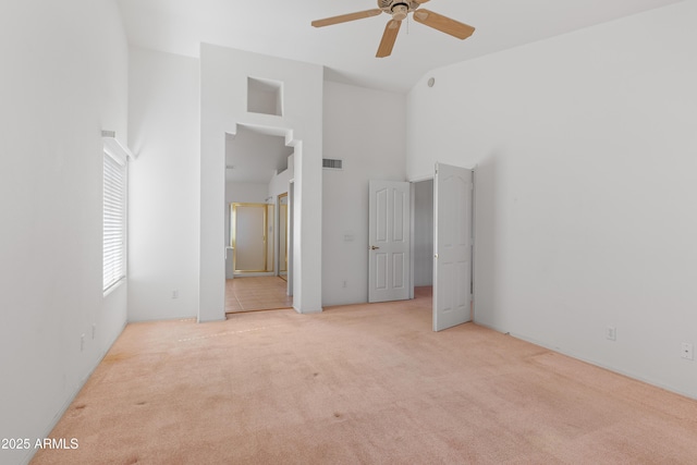 unfurnished bedroom featuring ensuite bathroom, high vaulted ceiling, visible vents, and light colored carpet