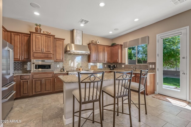 5813 E Ashler Hills Dr, Cave Creek, AZ 85331 - kitchen with brown cabinetry, wall chimney range hood, stainless steel appliances, and visible vents