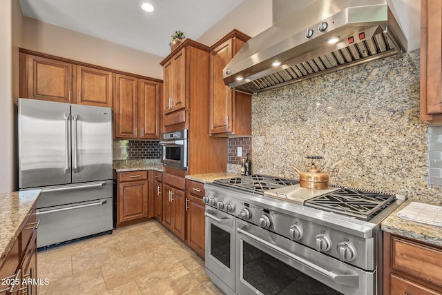 5813 E Ashler Hills Dr, Cave Creek, AZ 85331 - kitchen featuring high end appliances, brown cabinetry, wall chimney range hood, and tasteful backsplash
