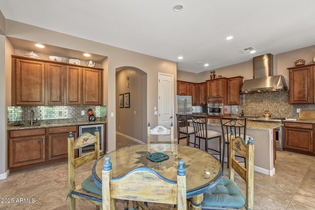 5813 E Ashler Hills Dr, Cave Creek, AZ 85331 - dining room with wine cooler, baseboards, arched walkways, and recessed lighting