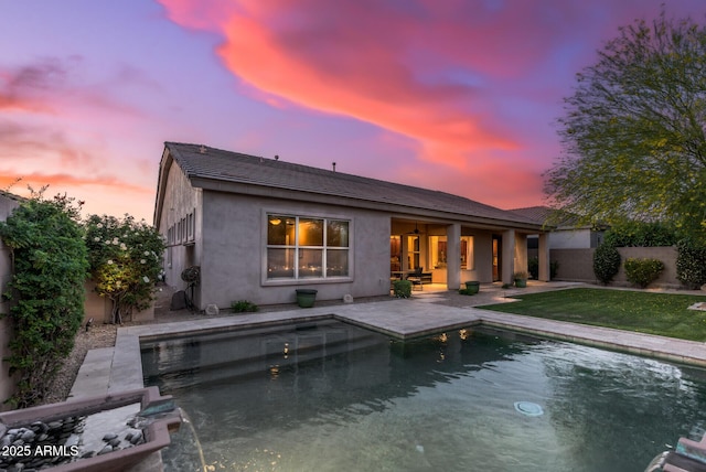 5813 E Ashler Hills Dr, Cave Creek, AZ 85331 - back of house at dusk featuring a fenced in pool, stucco siding, a patio area, a tile roof, and a lawn