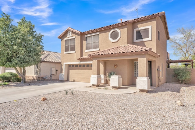 mediterranean / spanish-style home featuring stucco siding, an attached garage, concrete driveway, and fence