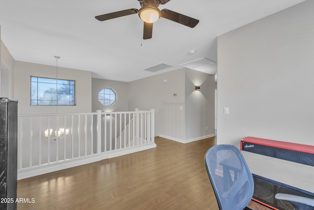 sitting room featuring wood finished floors, visible vents, baseboards, a notable chandelier, and an upstairs landing