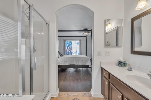 bathroom with connected bathroom, vanity, a shower stall, and a ceiling fan