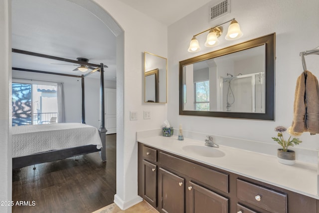 bathroom featuring visible vents, ceiling fan, ensuite bathroom, wood finished floors, and vanity