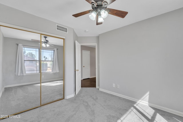 unfurnished bedroom featuring visible vents, a ceiling fan, a closet, carpet flooring, and baseboards