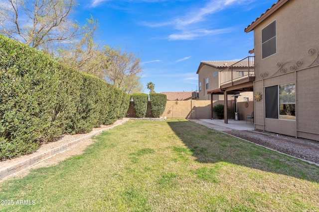 view of yard featuring a balcony, a fenced backyard, and a patio area