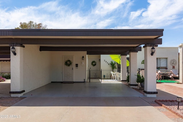 exterior space with fence, driveway, and a carport