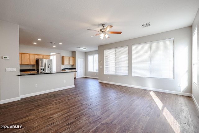 unfurnished living room with ceiling fan and dark hardwood / wood-style flooring