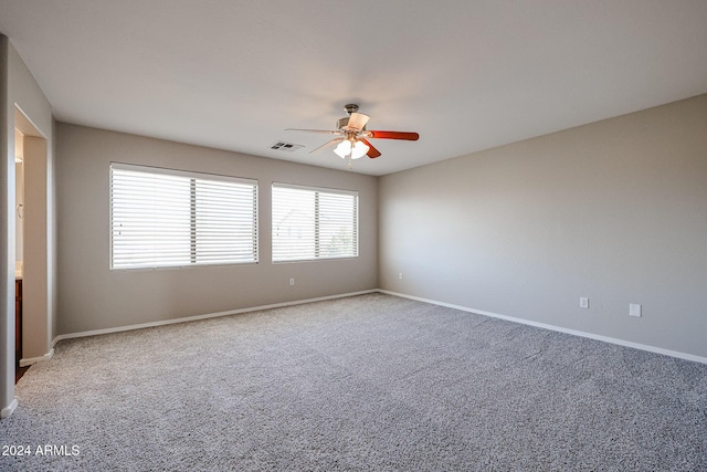 carpeted spare room featuring ceiling fan