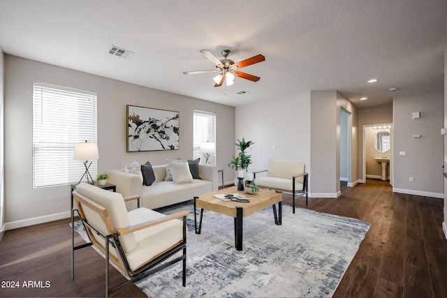 living room featuring ceiling fan and dark wood-type flooring