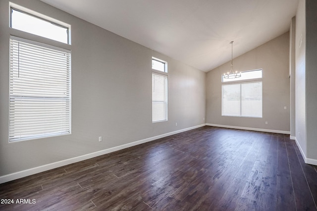 empty room featuring a chandelier, dark hardwood / wood-style floors, and vaulted ceiling