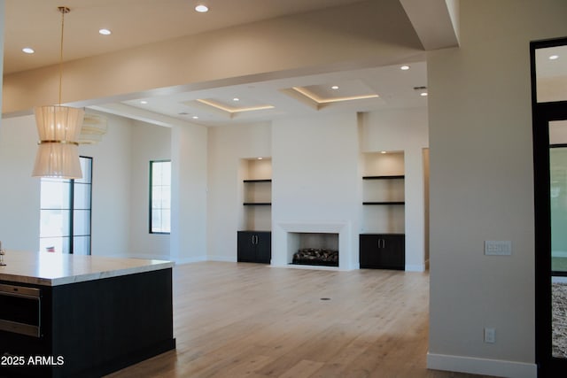 12863 E Cochise Rd, Scottsdale, AZ 85259 - unfurnished living room featuring built in shelves, light wood-style floors, a fireplace, and recessed lighting
