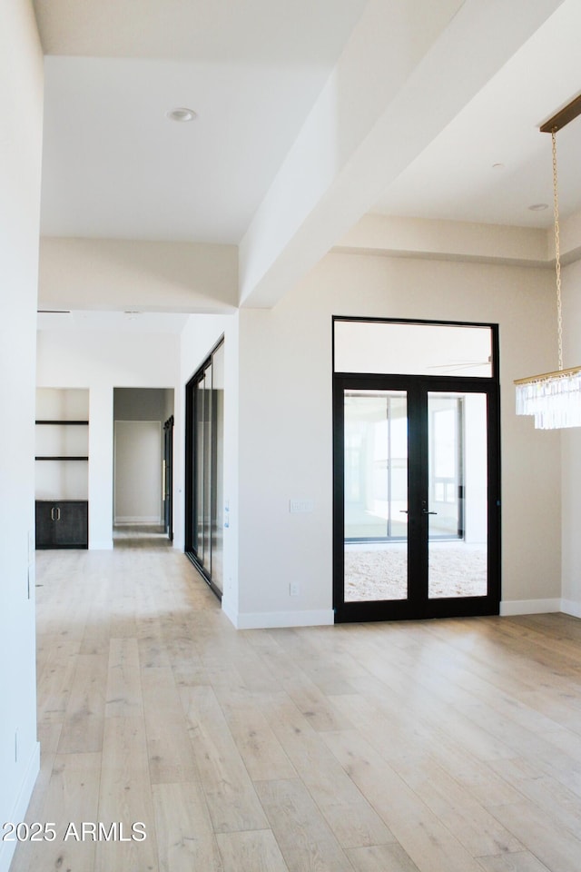 12863 E Cochise Rd, Scottsdale, AZ 85259 - unfurnished room featuring light wood-style flooring, french doors, and a chandelier