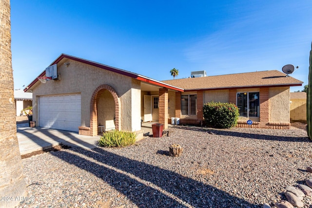 ranch-style home with a garage and central AC