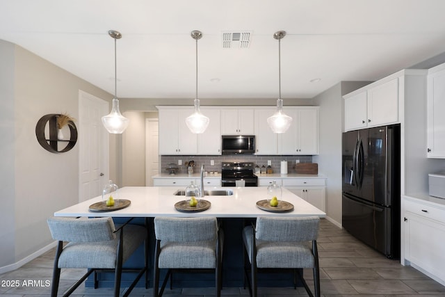 738 W Kingman Dr, Casa Grande, AZ 85122 - kitchen with range with electric stovetop, stainless steel microwave, visible vents, a sink, and black fridge
