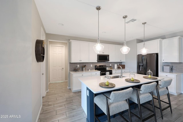738 W Kingman Dr, Casa Grande, AZ 85122 - kitchen featuring a breakfast bar area, light countertops, visible vents, appliances with stainless steel finishes, and a sink