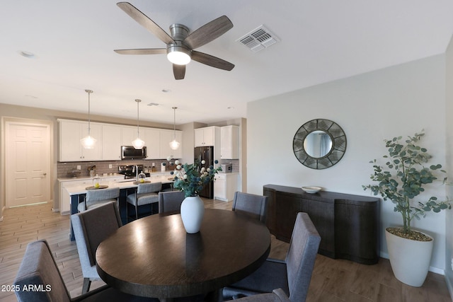 738 W Kingman Dr, Casa Grande, AZ 85122 - dining area with baseboards, light wood-type flooring, visible vents, and a ceiling fan