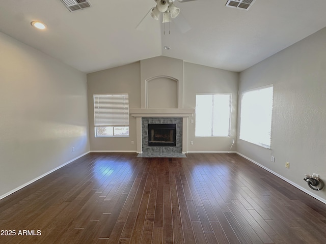 unfurnished living room with lofted ceiling, a fireplace, dark hardwood / wood-style floors, and a healthy amount of sunlight