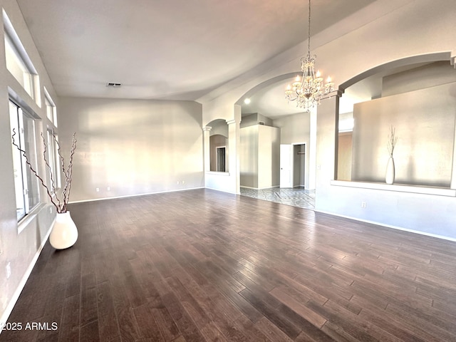 unfurnished living room featuring lofted ceiling, dark wood-type flooring, and a chandelier