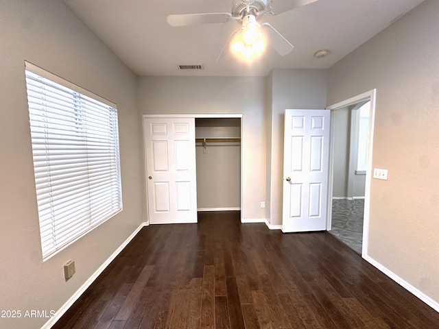 unfurnished bedroom featuring dark hardwood / wood-style floors, ceiling fan, and a closet