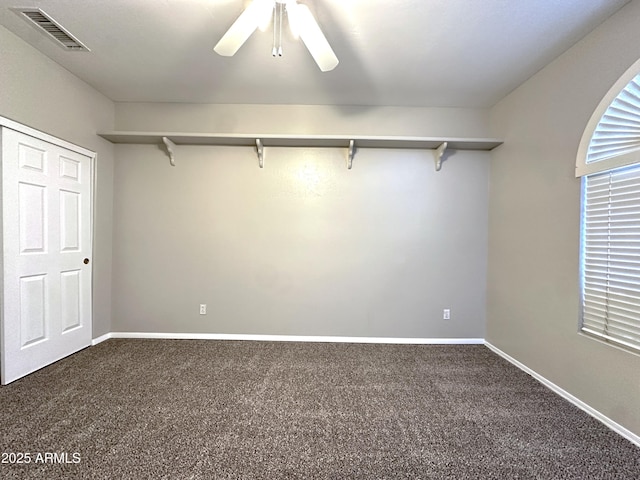 unfurnished bedroom with dark colored carpet and ceiling fan