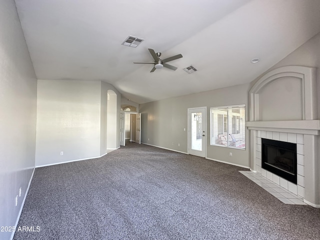 unfurnished living room with lofted ceiling, a fireplace, ceiling fan, and carpet