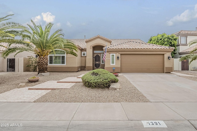 1391 W Windhaven Ave, Gilbert, AZ 85233 - mediterranean / spanish home featuring stucco siding, an attached garage, fence, a tiled roof, and concrete driveway
