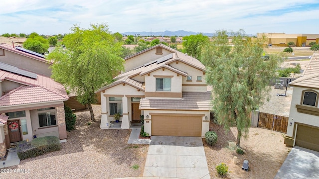 2016 S 102nd Ln, Tolleson, AZ 85353 - view of front facade with stucco siding, driveway, an attached garage, a mountain view, and solar panels