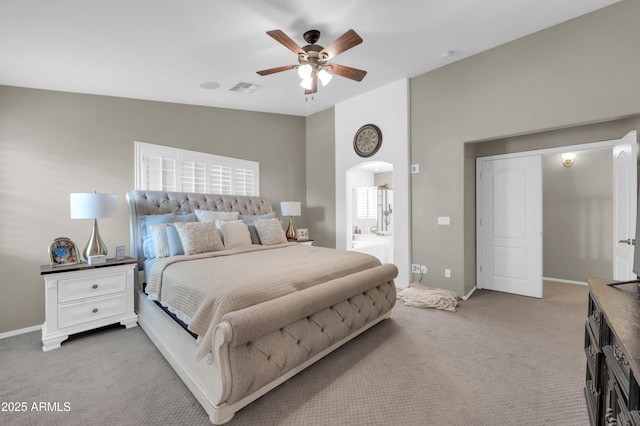 2016 S 102nd Ln, Tolleson, AZ 85353 - carpeted bedroom featuring baseboards, arched walkways, ceiling fan, and ensuite bathroom