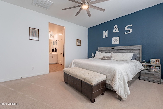 bedroom with light carpet, ceiling fan, and ensuite bathroom