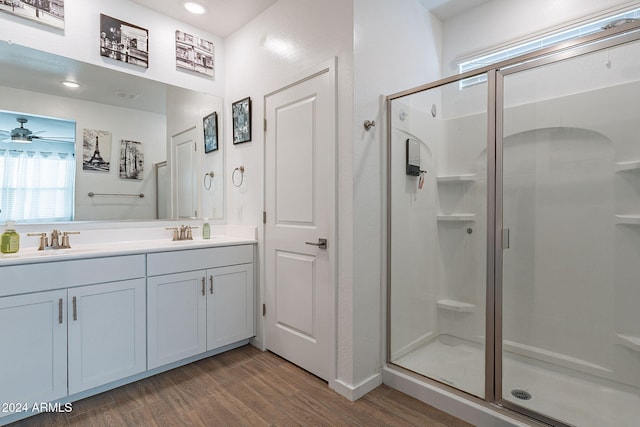 bathroom with wood-type flooring, vanity, ceiling fan, and a shower with shower door