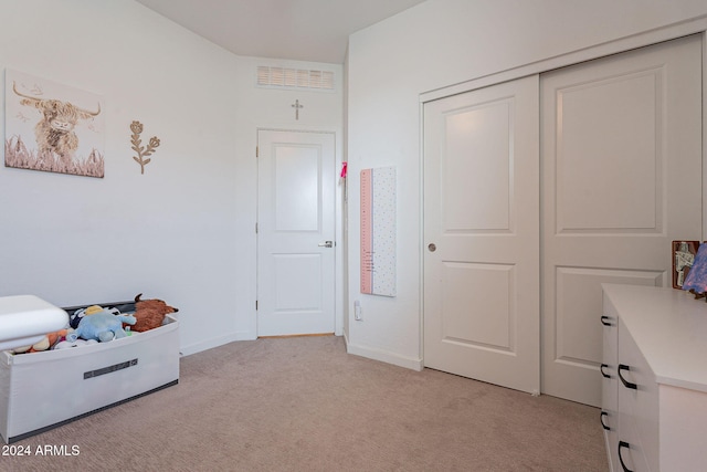 bedroom featuring light carpet and a closet