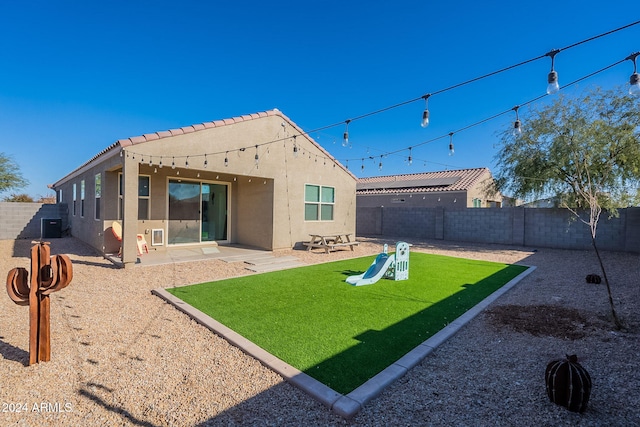 rear view of house with a lawn and a patio area