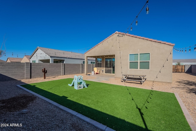 rear view of property featuring a patio area and a lawn