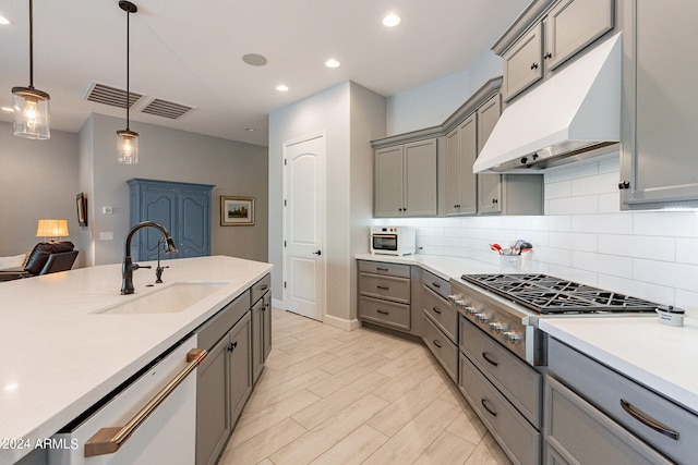 kitchen with hanging light fixtures, stainless steel gas cooktop, sink, tasteful backsplash, and dishwasher