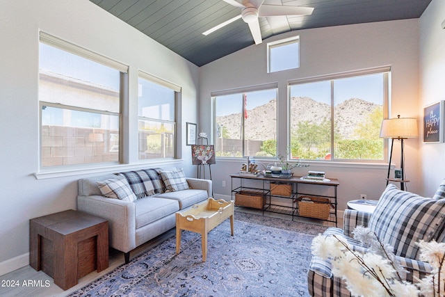 living room featuring a wealth of natural light, lofted ceiling, ceiling fan, and a mountain view