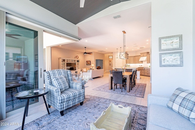 living room featuring sink, ceiling fan, and lofted ceiling