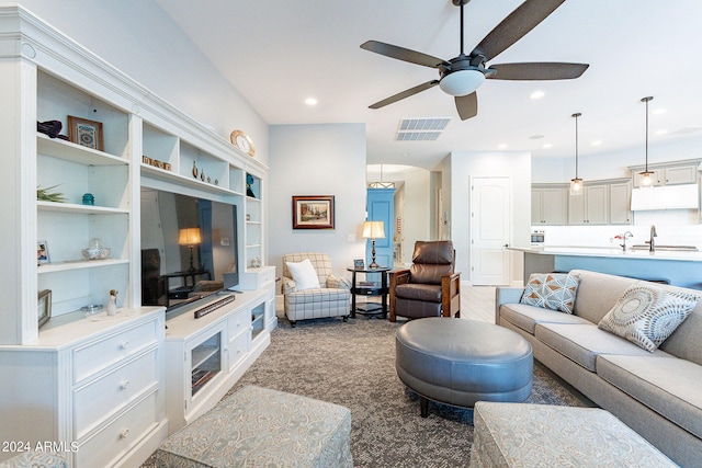 carpeted living room featuring built in features, ceiling fan, and sink