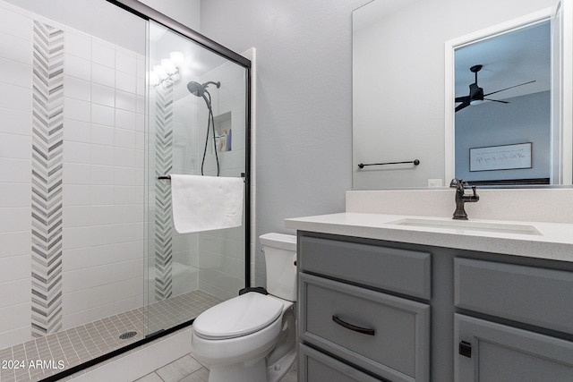 bathroom featuring walk in shower, ceiling fan, tile floors, vanity, and toilet