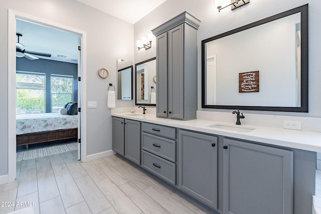 bathroom featuring ceiling fan, oversized vanity, and dual sinks