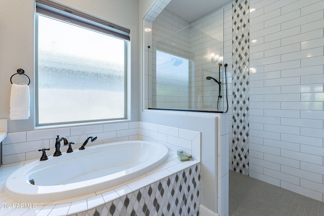 bathroom with a wealth of natural light and independent shower and bath