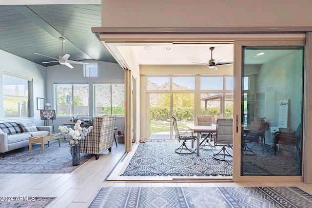 sunroom featuring a wealth of natural light, ceiling fan, and vaulted ceiling