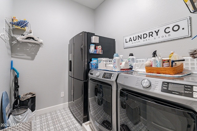 laundry area with washer and dryer and light tile floors