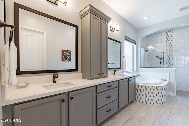 bathroom with double sink, plus walk in shower, and oversized vanity