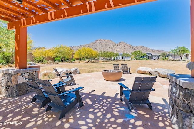 view of patio / terrace with a pergola, a mountain view, and an outdoor fire pit