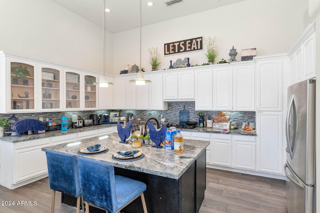 kitchen with stainless steel refrigerator, backsplash, and a kitchen island