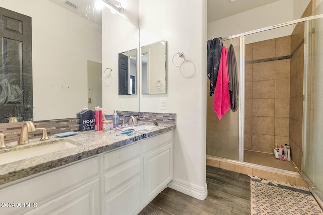 bathroom with an enclosed shower, double vanity, and hardwood / wood-style floors