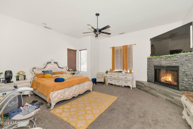 carpeted bedroom featuring a fireplace and ceiling fan